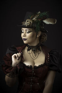 Woman in costume against black background