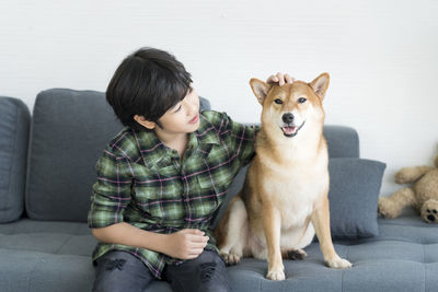 Rear view of boy sitting on sofa