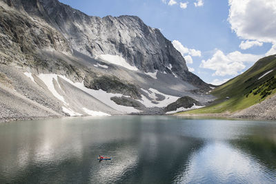 Idyllic shot of lake with mountain in background and women floating