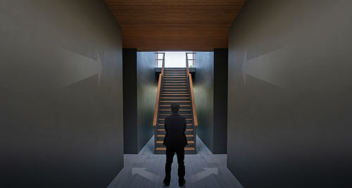 Rear view of person standing in corridor of building