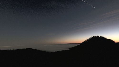Scenic view of silhouette landscape against sky at night