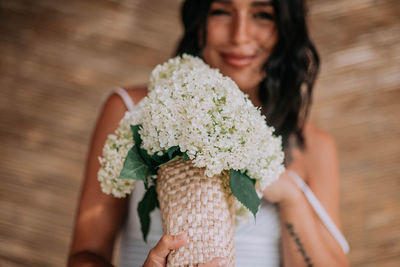 Midsection of woman holding flower bouquet