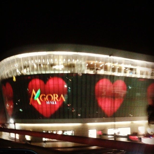 red, indoors, illuminated, text, transportation, night, western script, communication, glass - material, car, land vehicle, mode of transport, no people, close-up, reflection, transparent, architecture, city, incidental people, capital letter