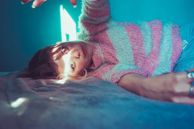 Low angle view of girl lying on bed