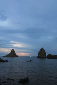 Scenic view of rocks in sea against sky