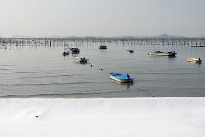 Boats moored on sea against clear sky