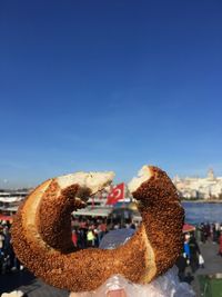 Close-up of hand holding ice cream against blue sky