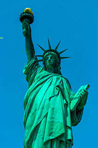 Low angle view of statue against blue sky