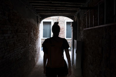 In silhouette woman walking in tunnel in building