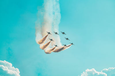 Low angle view of airplane flying against blue sky