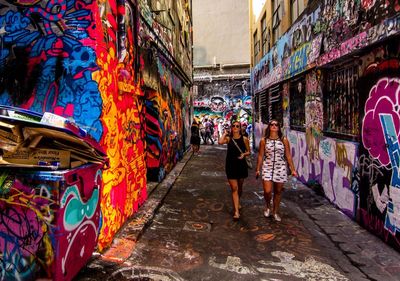 Woman standing in front of graffiti wall