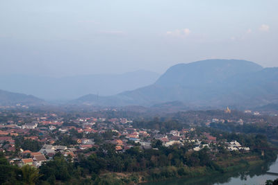 Aerial view of townscape and mountains against sky