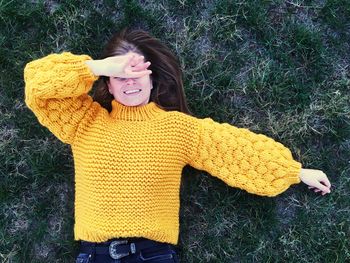 High angle view of smiling young woman lying on grass