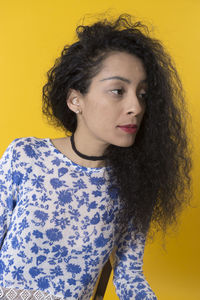 Portrait of beautiful woman with yellow hair against orange wall