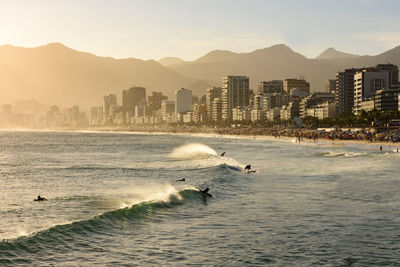 Scenic view of sea and cityscape against clear sky