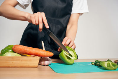 Midsection of woman preparing food on cutting board