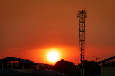 Low angle view of silhouette building against orange sky