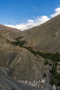 Road leading towards mountains against sky