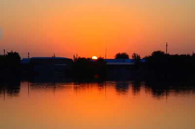 Scenic view of lake against orange sky