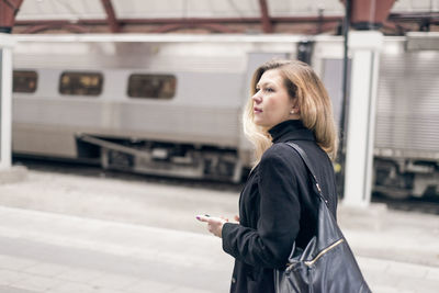 Woman looking around at train station