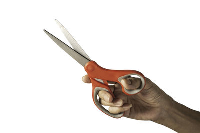 Close-up of hand holding metal against white background