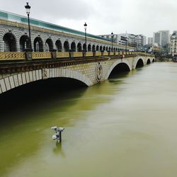 Arch bridge over river against sky