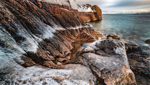 Rock formation in sea against sky