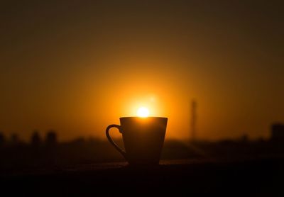 Optical illusion of sun over coffee cup