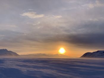 Scenic view of snowcapped mountains against sky during sunset