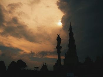 Silhouette built structure against cloudy sky during sunset