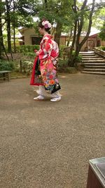 Rear view of a woman standing on tree trunk