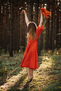 Peace of mind, breathing fresh air. alone woman in red dress enjoys the tranquility and calm