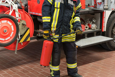 Midsection of firefighter standing on footpath