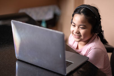 Cute girl using laptop at home