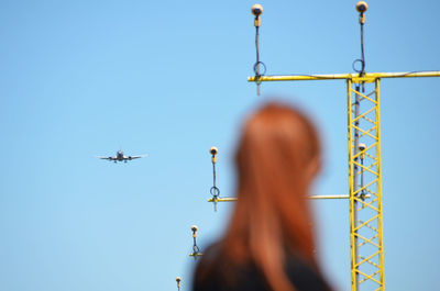 Defocused image of woman standing against landing lights