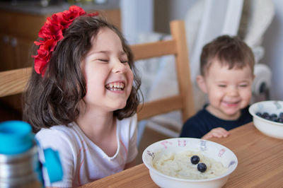 Siblings fooling around at the breakfast table