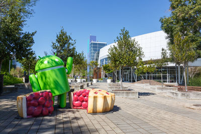 Fruits and plants in city against clear sky