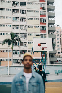 Portrait of man standing against building in city