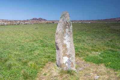 Stone wall on field against clear sky