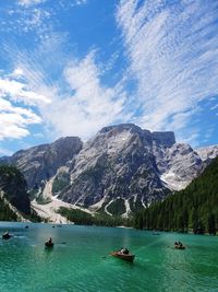 Scenic view of boats in lake against cloudy sky