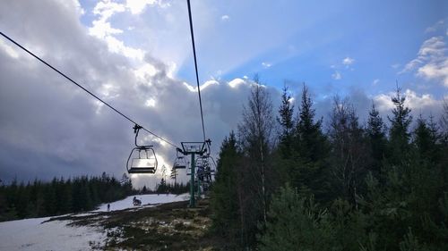 Built structure by trees against sky during winter