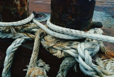 High angle view of rope tied to wooden post at harbor