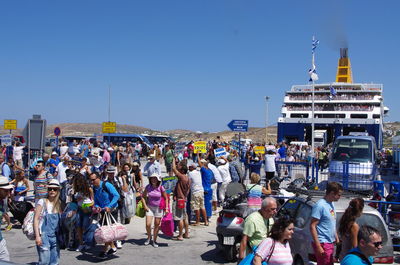 People on street against clear blue sky