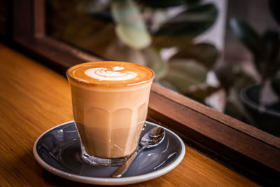 A cup of coffee latte top view with leaf shape foam