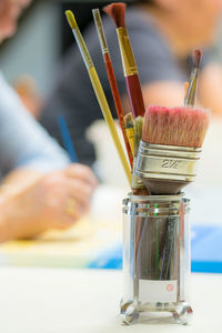 Close-up of paintbrushes in small container on table