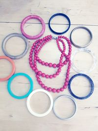 High angle view of colorful bangles with necklace on table