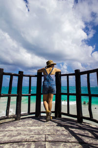 Rear view of woman standing on pier