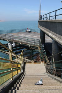 Man on pier over sea against sky