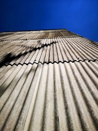 Low angle view of building roof against clear blue sky