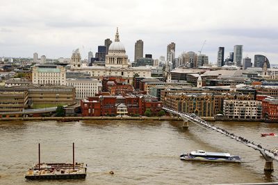 Boats in river with city in background